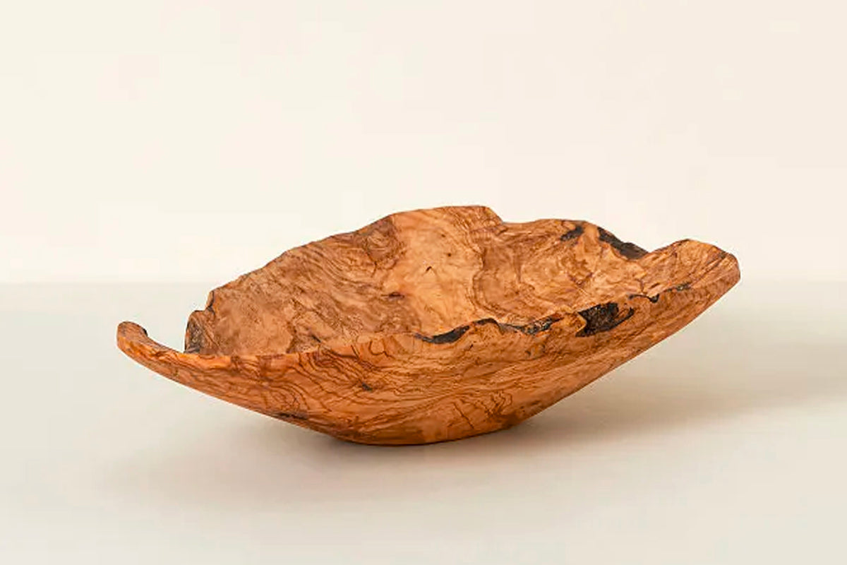 Hand-carved olivewood bowl with natural grain patterns and irregular organic edges.