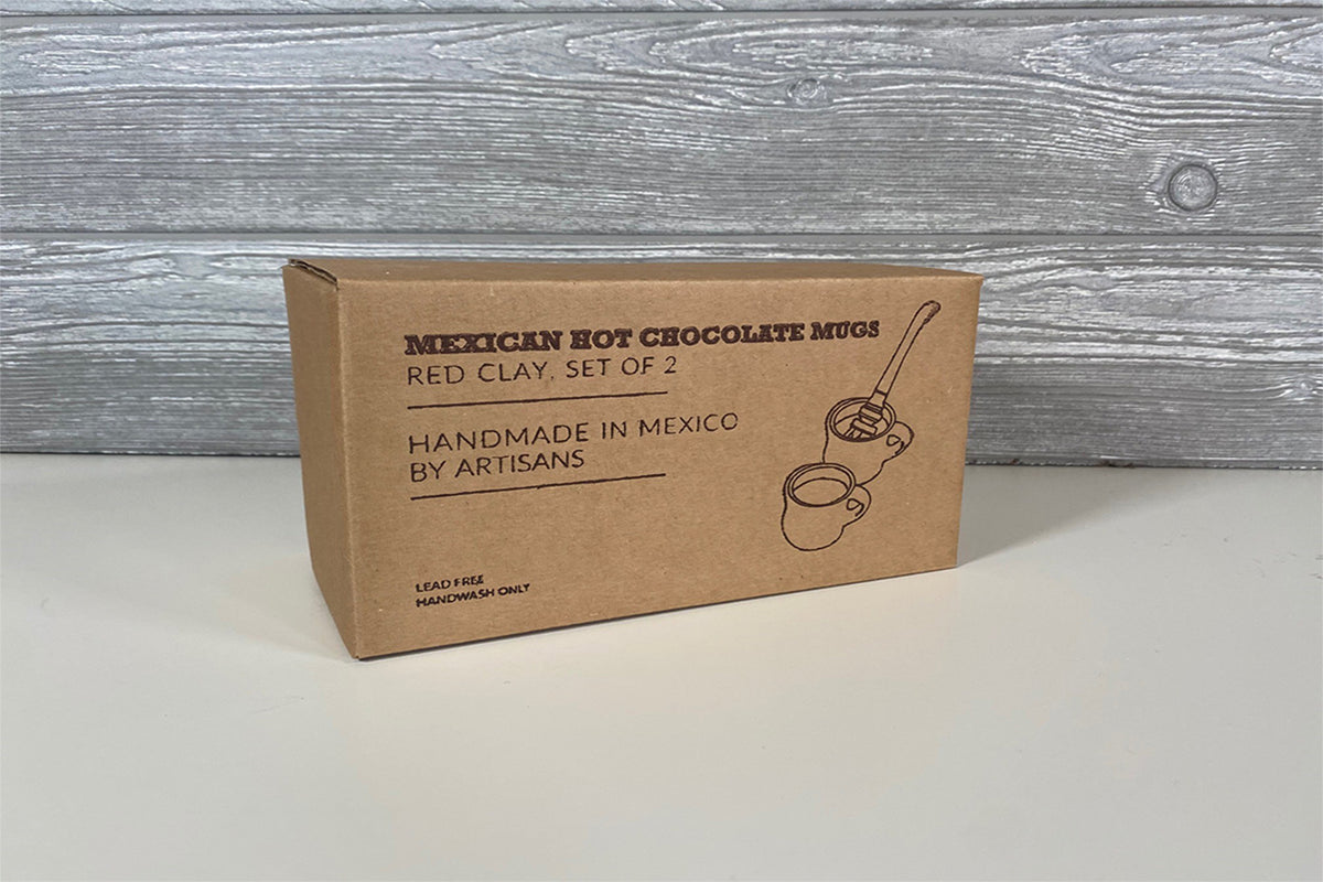 Brown cardboard box labeled "Mexican Hot Chocolate Mugs Red Clay, Set of 2" with illustrated mug and whisk design.