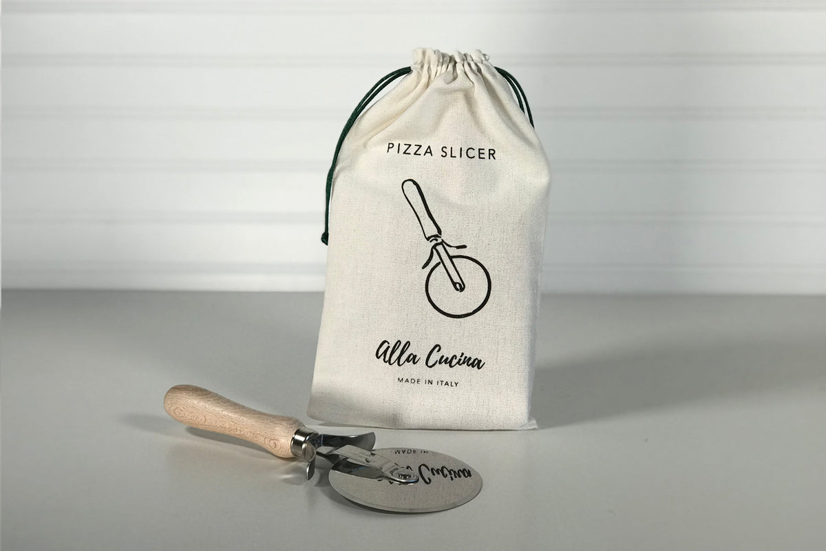 Pizza slicer with natural wood handle and metal wheel blade, shown with cream drawstring storage pouch.
