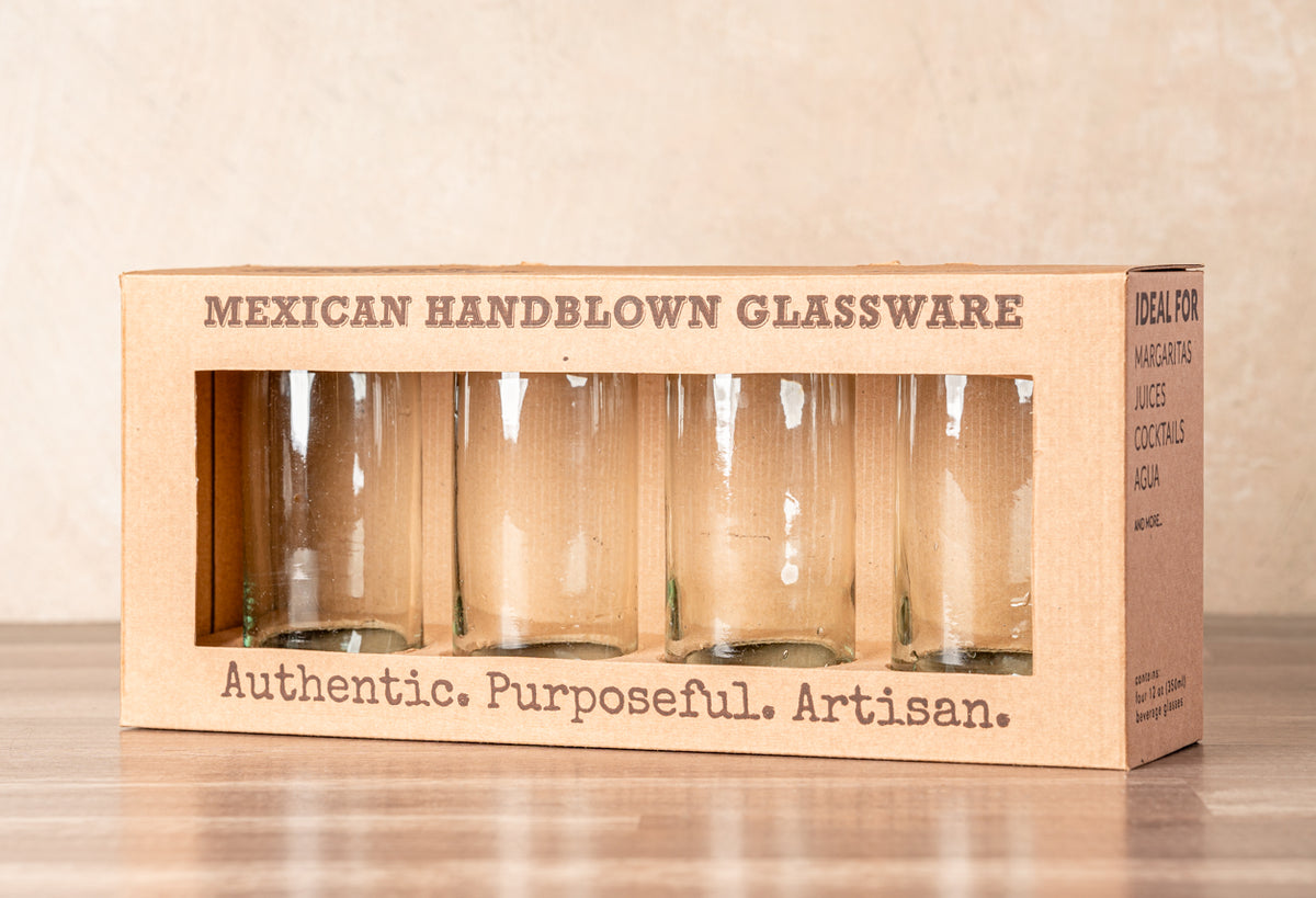 Set of four clear handblown glasses in cardboard packaging with window display.