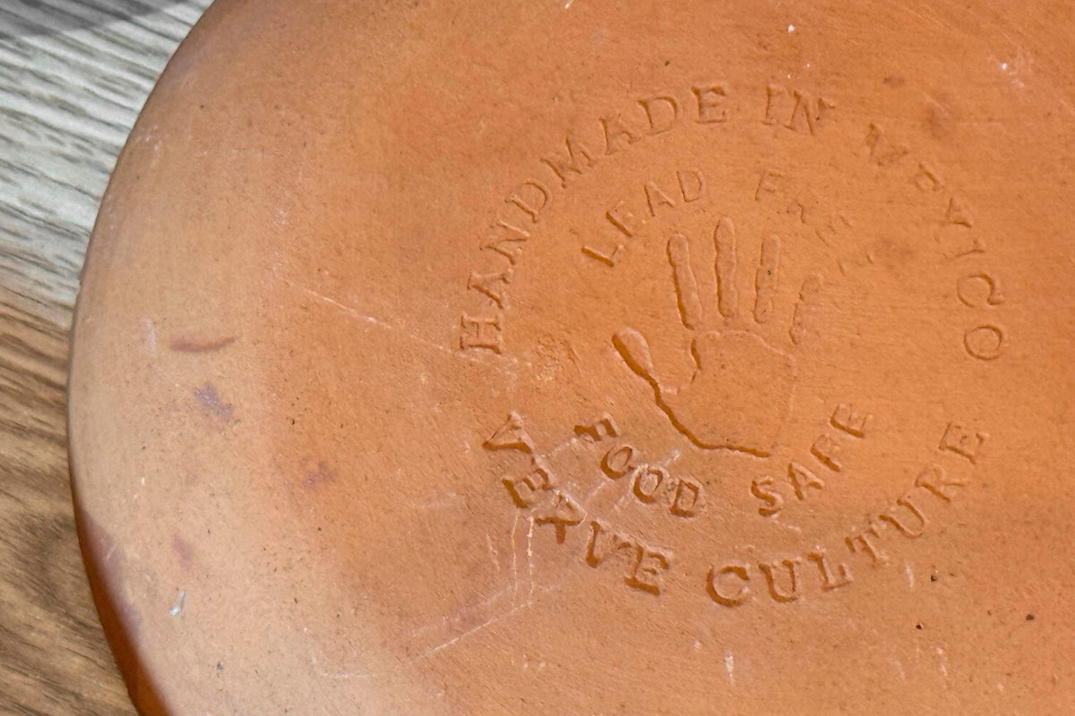 Terracotta ceramic plate with embossed handprint and text reading "Handmade," "Lead Free," and "God Save Culture."