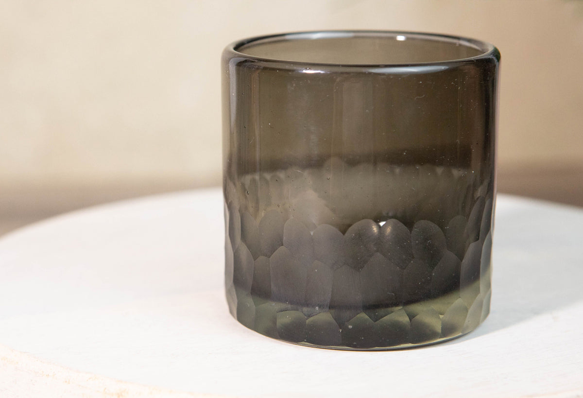 Smoke-tinted rocks glass with etched geometric pattern around lower half and clear rim.