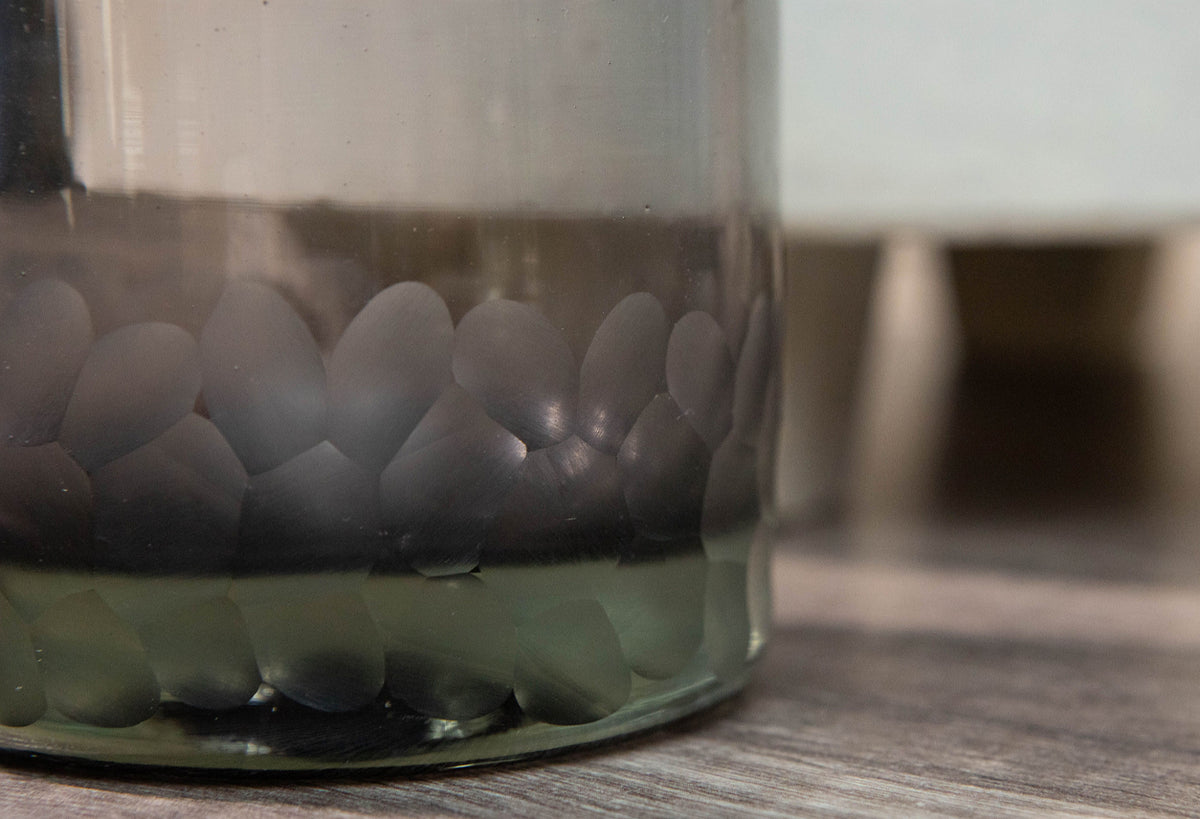 Two clear rocks glasses with etched circular pattern around lower portion, one in focus in foreground.