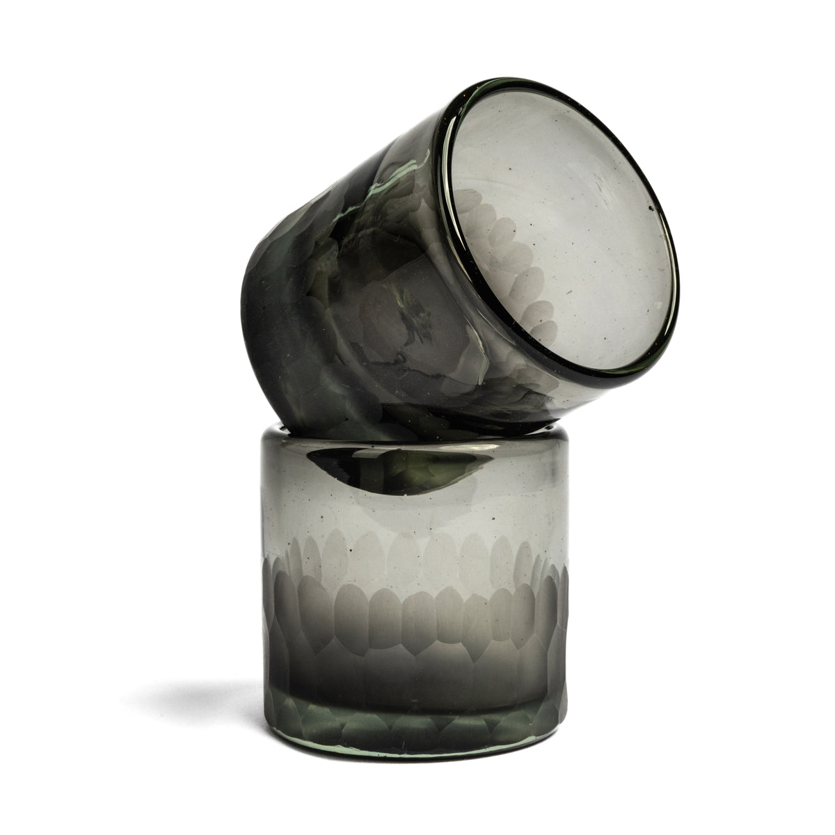 Two handblown glasses with etched geometric pattern, one tilted atop the other, in smoky gray with black rims.