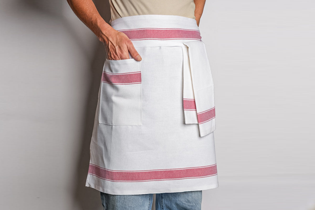 White half apron with red stripes, front pocket, and matching waist tie.