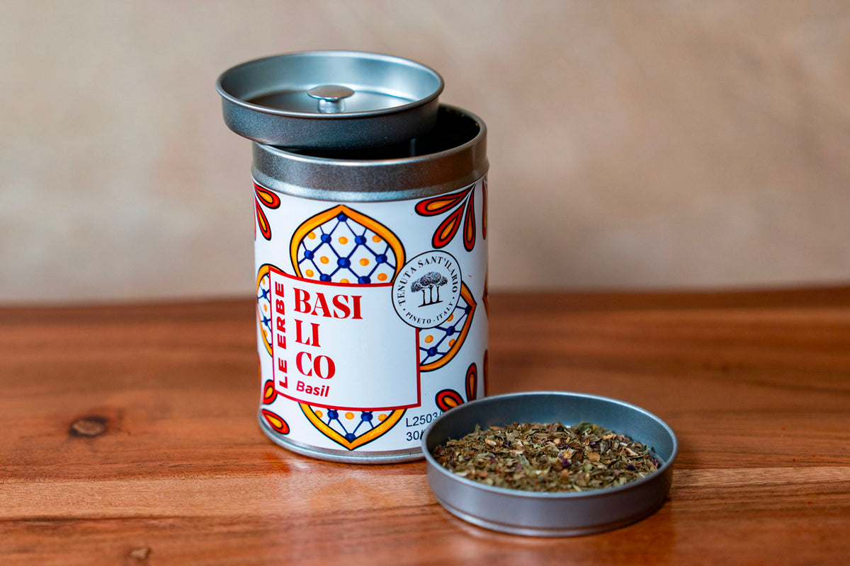 Basil herb tin container with metal lid and open dish showing dried green herb pieces.