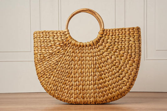 Woven straw tote bag with circular wooden handle in natural tan color.