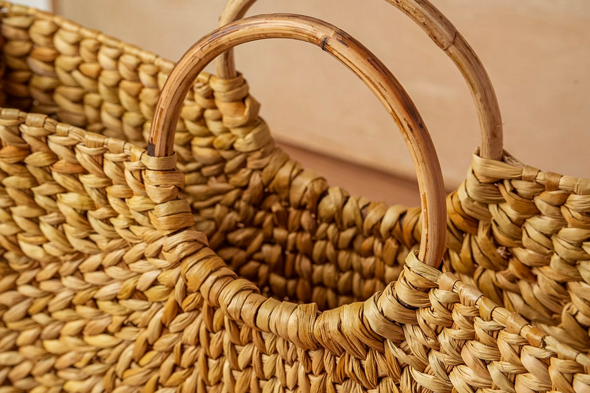 Woven natural fiber tote bag with two curved wooden circle handles.