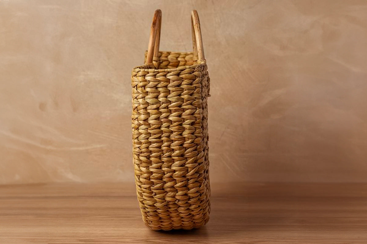 Woven natural fiber tote bag with curved wooden circle handles in tan and brown tones.