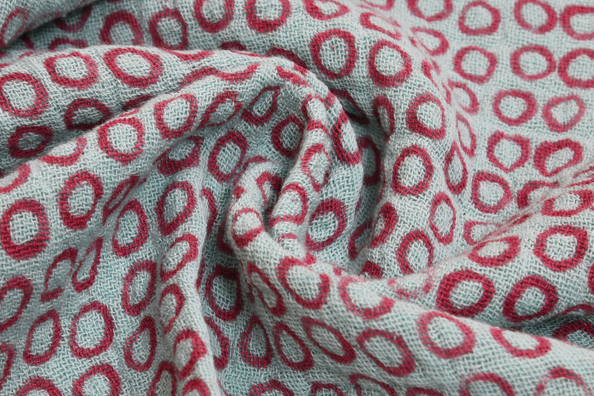 Cream and red block printed cotton napkins with geometric floral pattern, folded to show texture and weave detail.