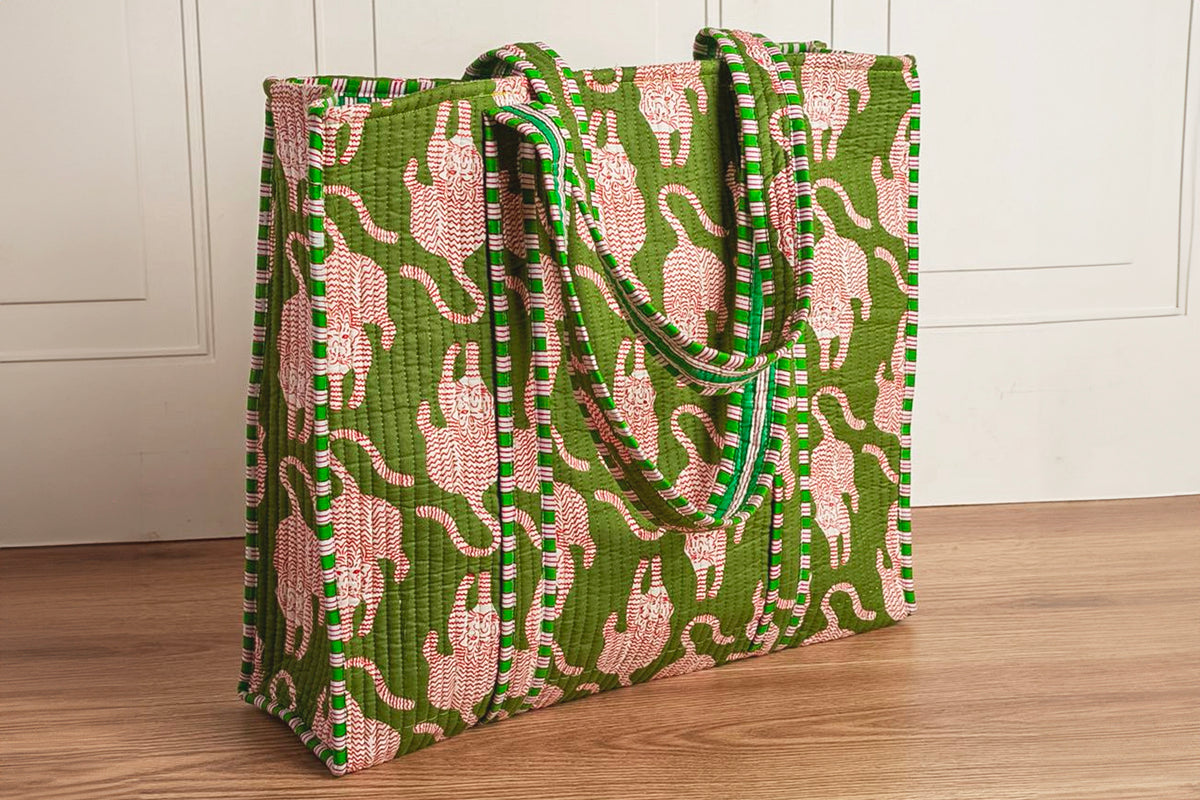 Green quilted tote bag with pink cat pattern and striped green handles.