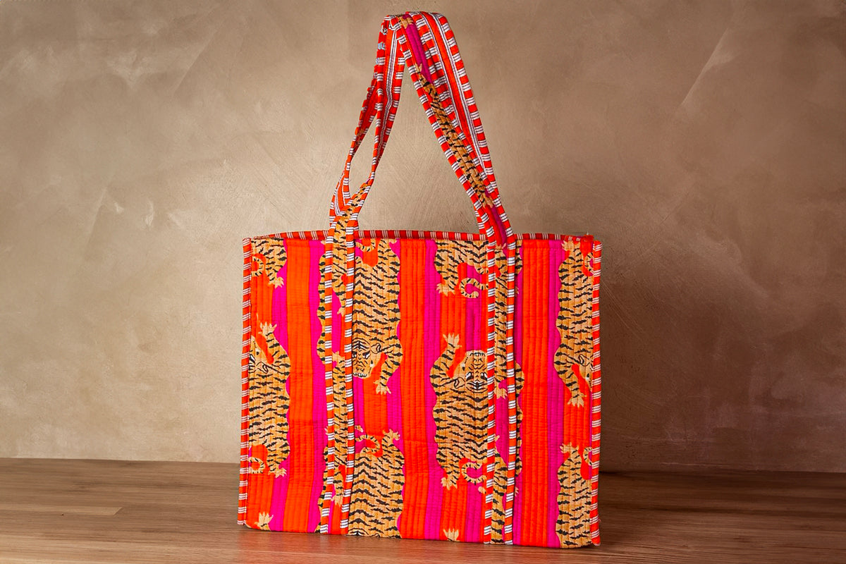 Red quilted tote bag with tiger stripe and floral patterns, dual handles with matching fabric trim.