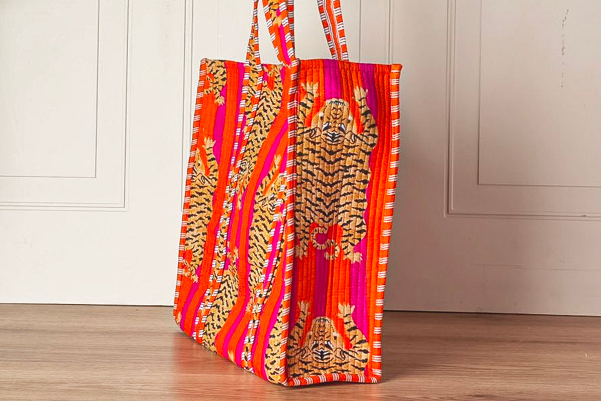 Red and gold quilted tote bag with tiger stripe pattern and matching patterned handles.