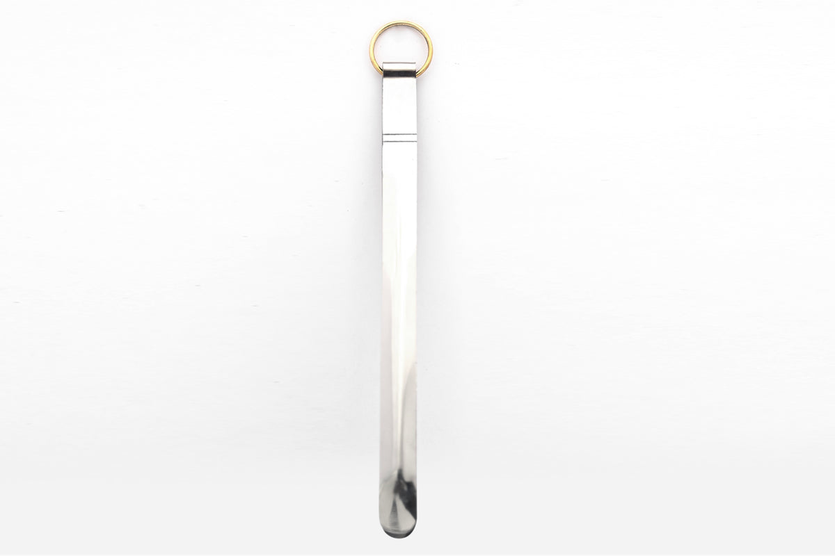 Silver metal tongs with brass ring handle and curved gripping ends.