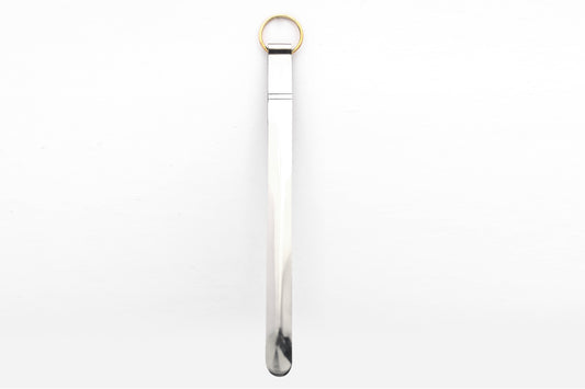 Silver metal tongs with brass ring handle and curved gripping ends.