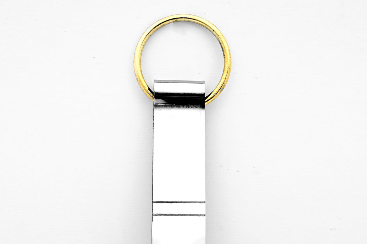 Metal tongs with brass ring handle and two prongs extending downward.