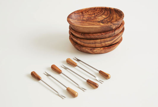 Stacked olivewood serving bowls with six metal picks featuring wooden handles.