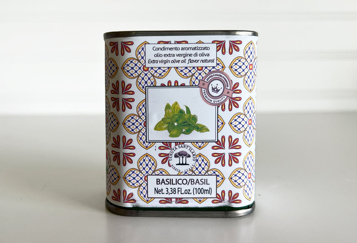 Basil-infused extra virgin olive oil in a 100ml tin with decorative red and blue geometric patterned label.