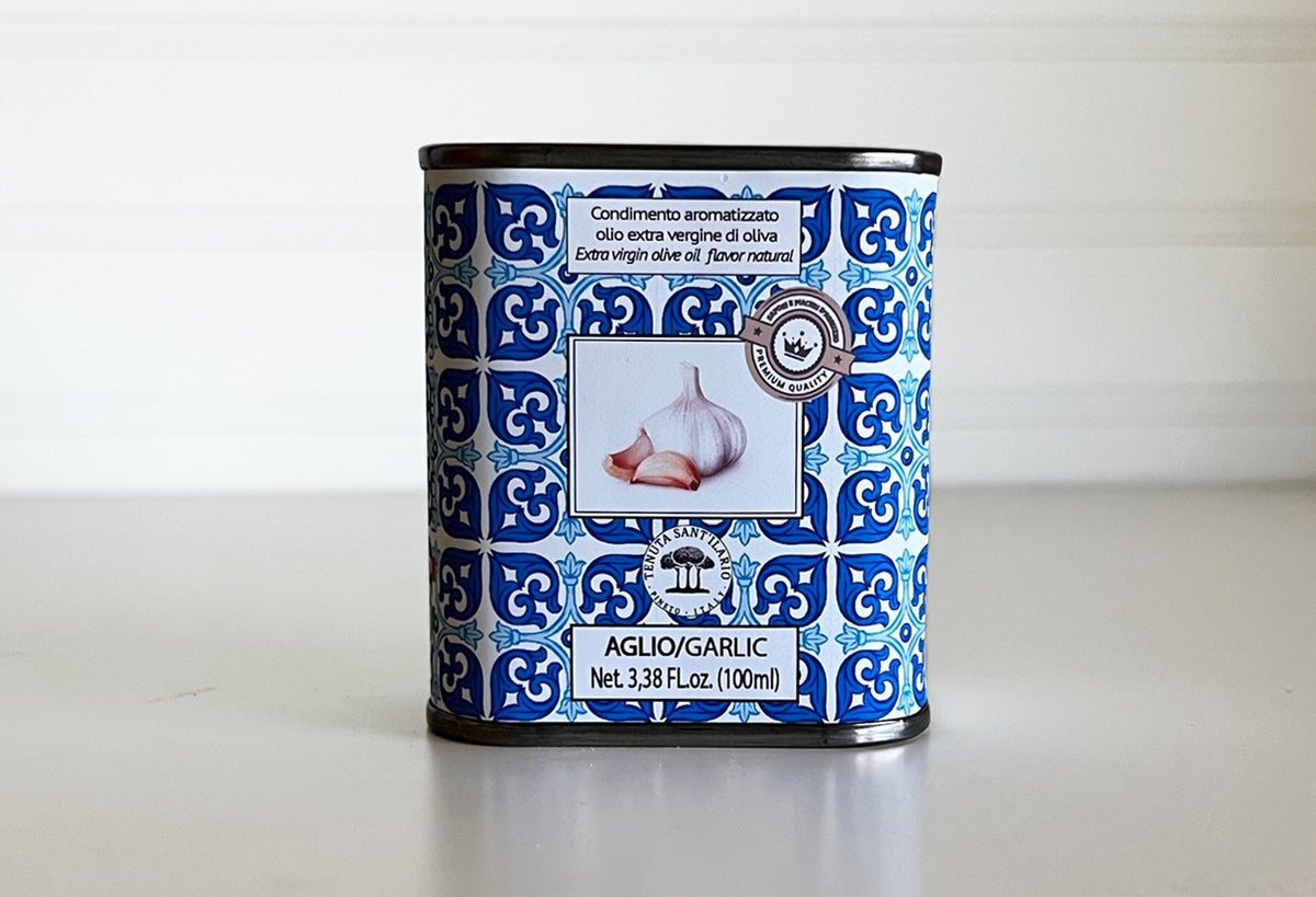 Blue and white patterned tin container of garlic-infused extra virgin olive oil, 3.38 fl oz.