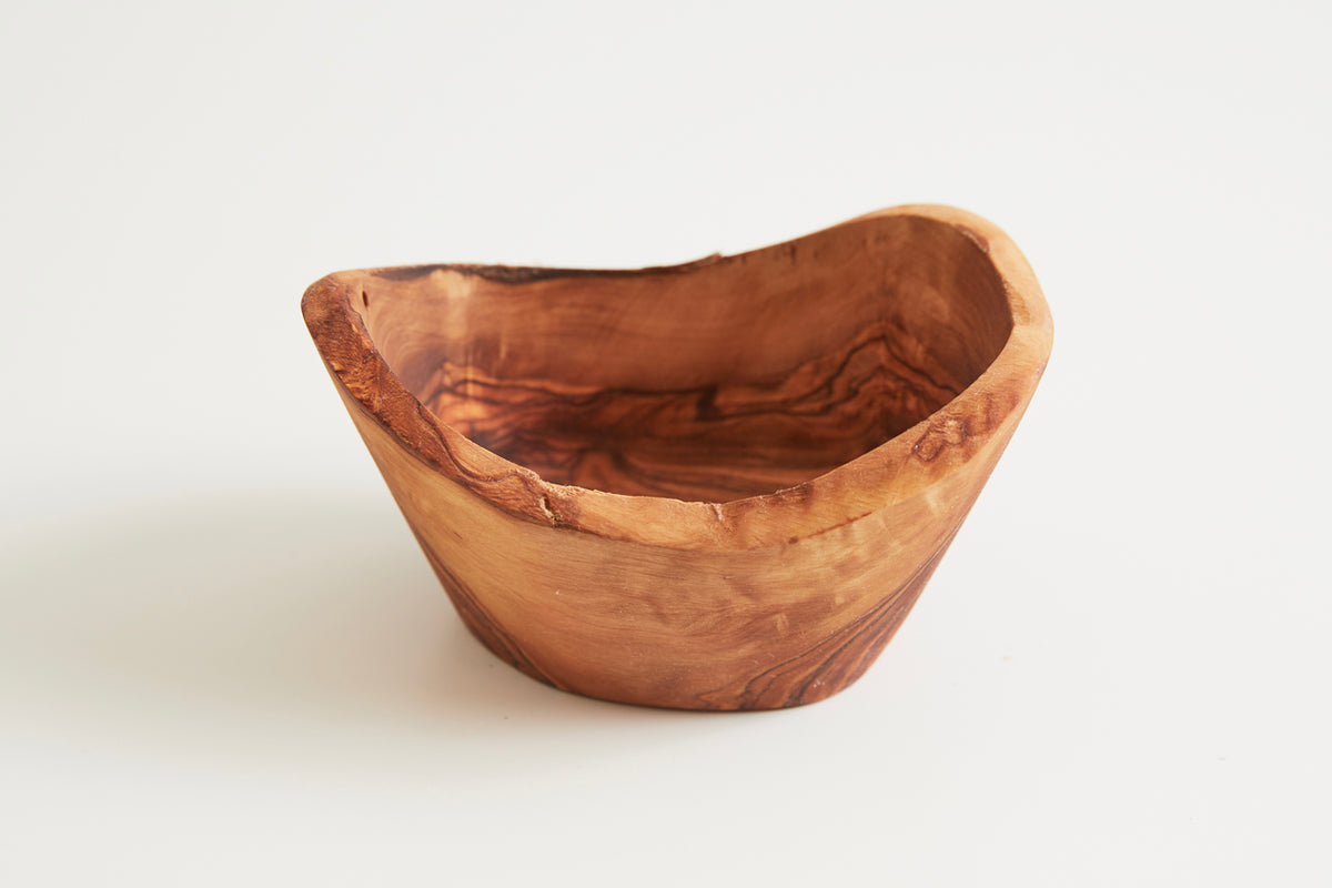 Hand-carved olivewood serving bowl with natural grain patterns and organic asymmetrical shape.