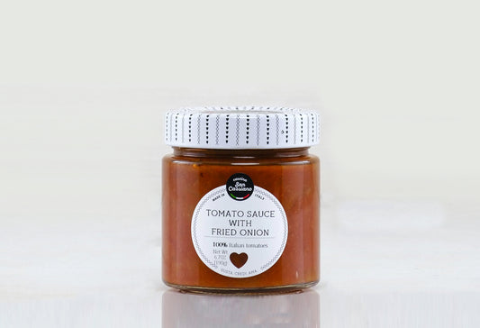 Glass jar with white patterned lid containing reddish-brown tomato sauce with visible fried onion pieces and product label.