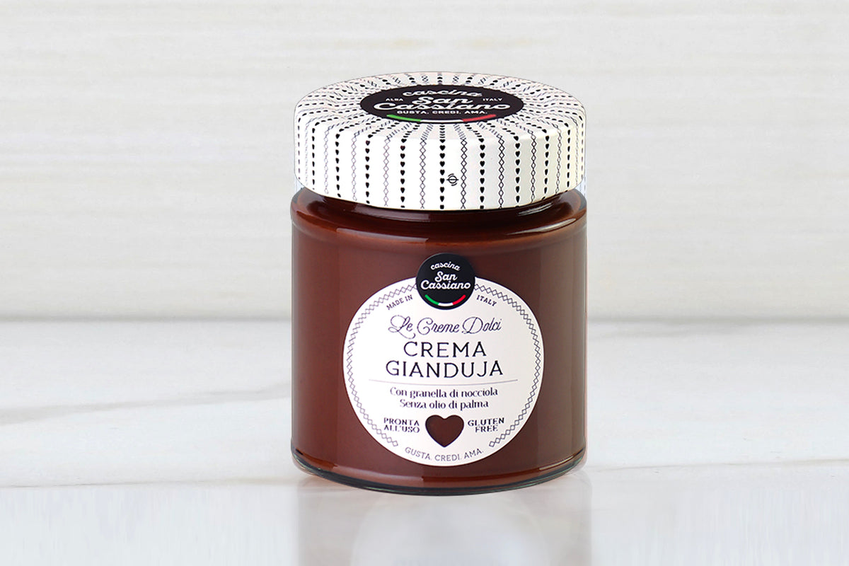 Glass jar with white patterned lid containing dark brown cocoa hazelnut spread labeled "Crema Gianduja."