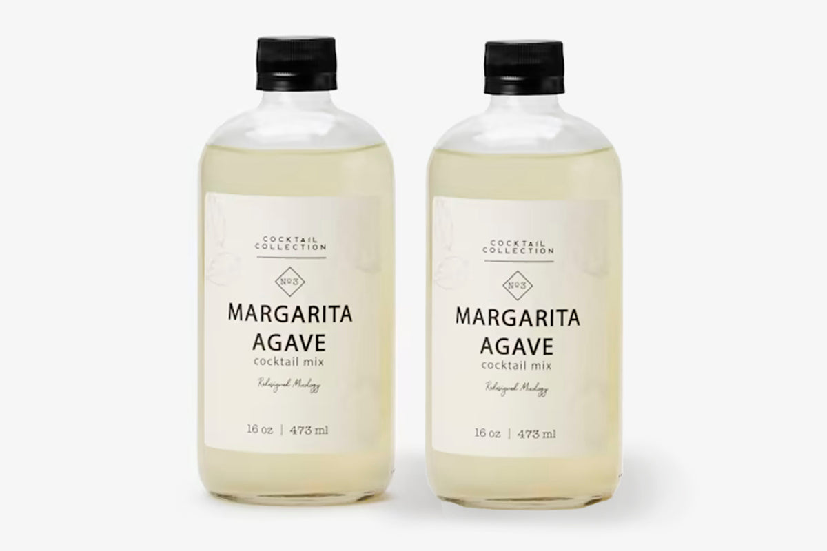 Two 16 oz bottles of pale yellow margarita agave cocktail mixer with black caps and cream-colored labels.