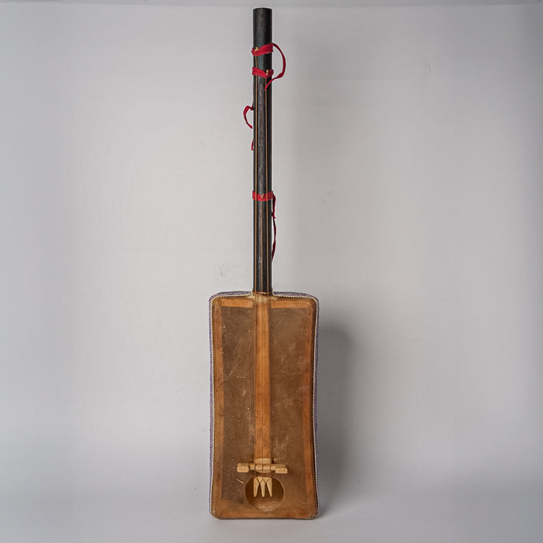 Wooden gimbri with dark neck, red tuning pegs, and rectangular resonance chamber against white background.
