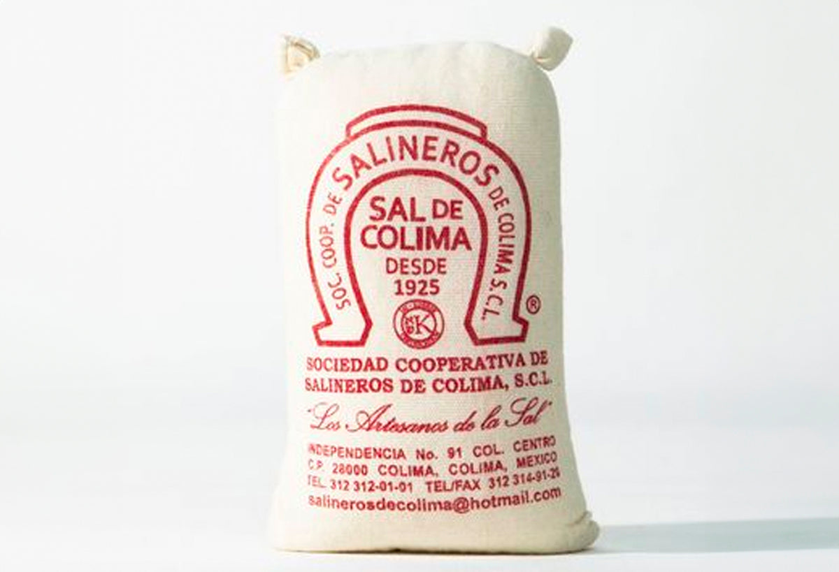 Cream linen bag with red text and horseshoe logo labeled "Sal de Colima" sea salt product.