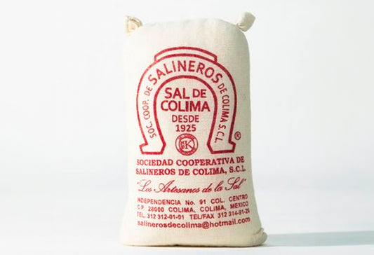 Cream linen bag with red text and horseshoe logo labeled "Sal de Colima" sea salt product.