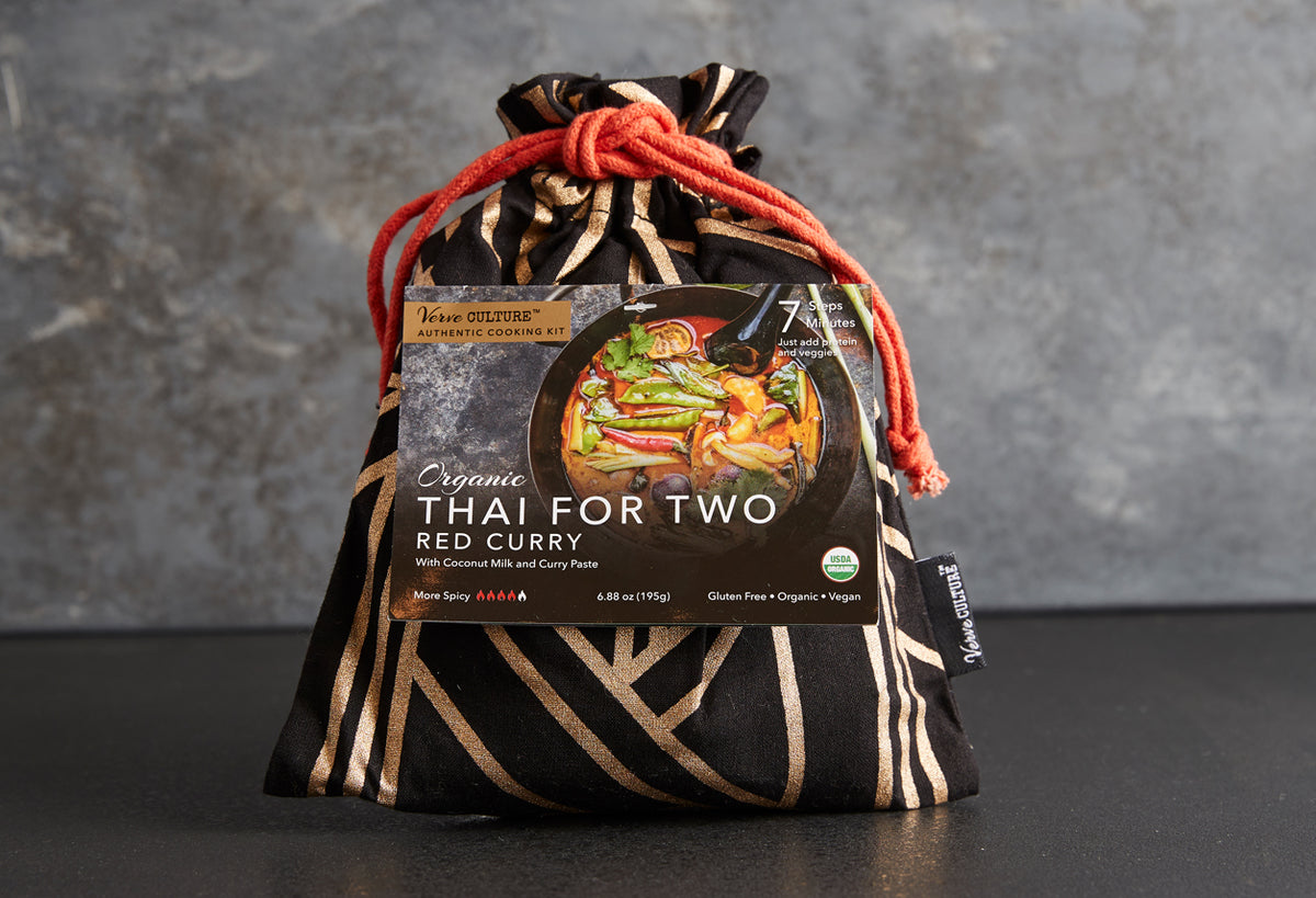 Organic Thai red curry cooking kit in black and gold patterned drawstring pouch with red cord closure.