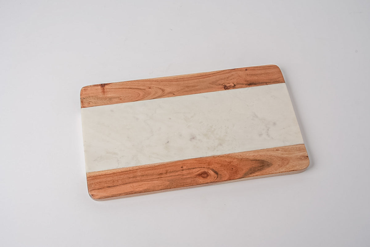 Rectangular serving board with light marble center strip flanked by acacia wood sides.