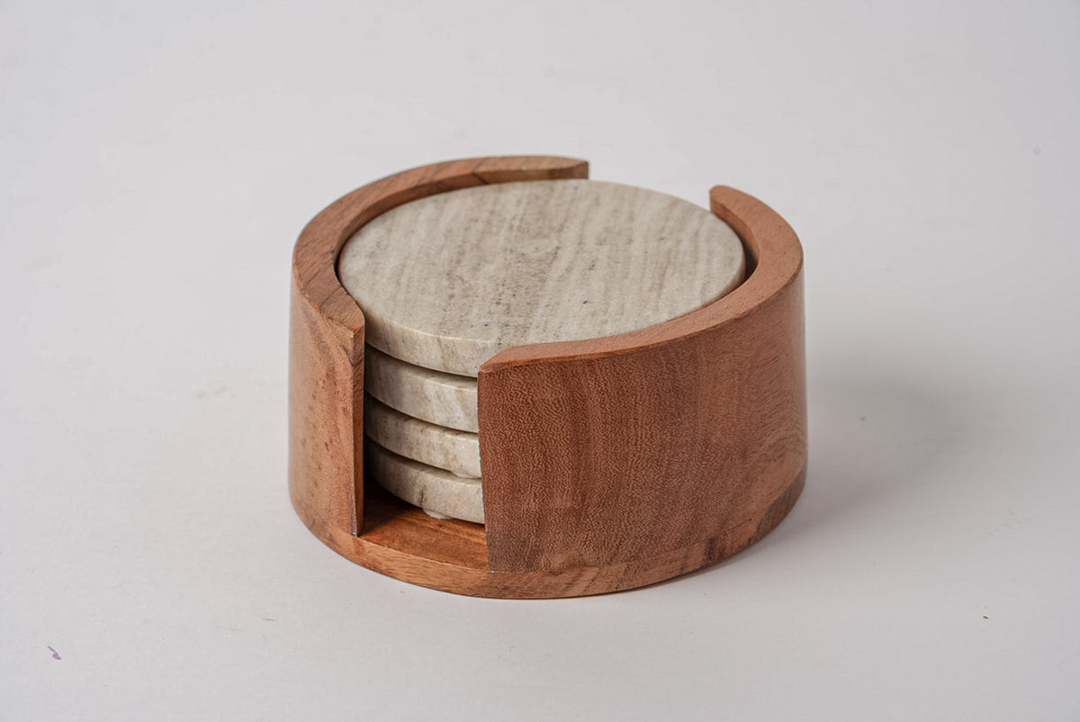 Four tan marble coasters stacked in a wooden holder with an open side slot.