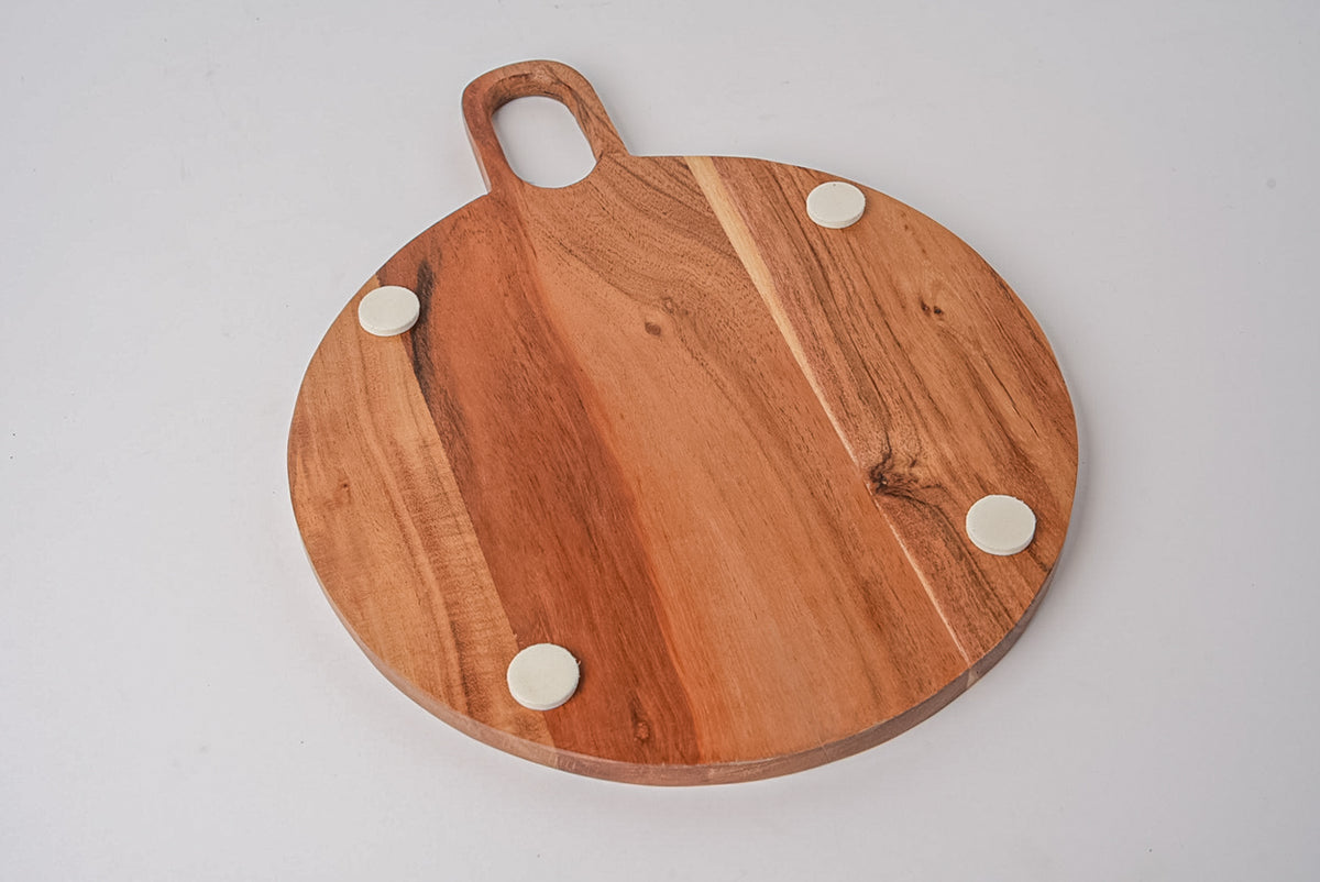 Round wooden serving board with handle and four white pegs for holding items.
