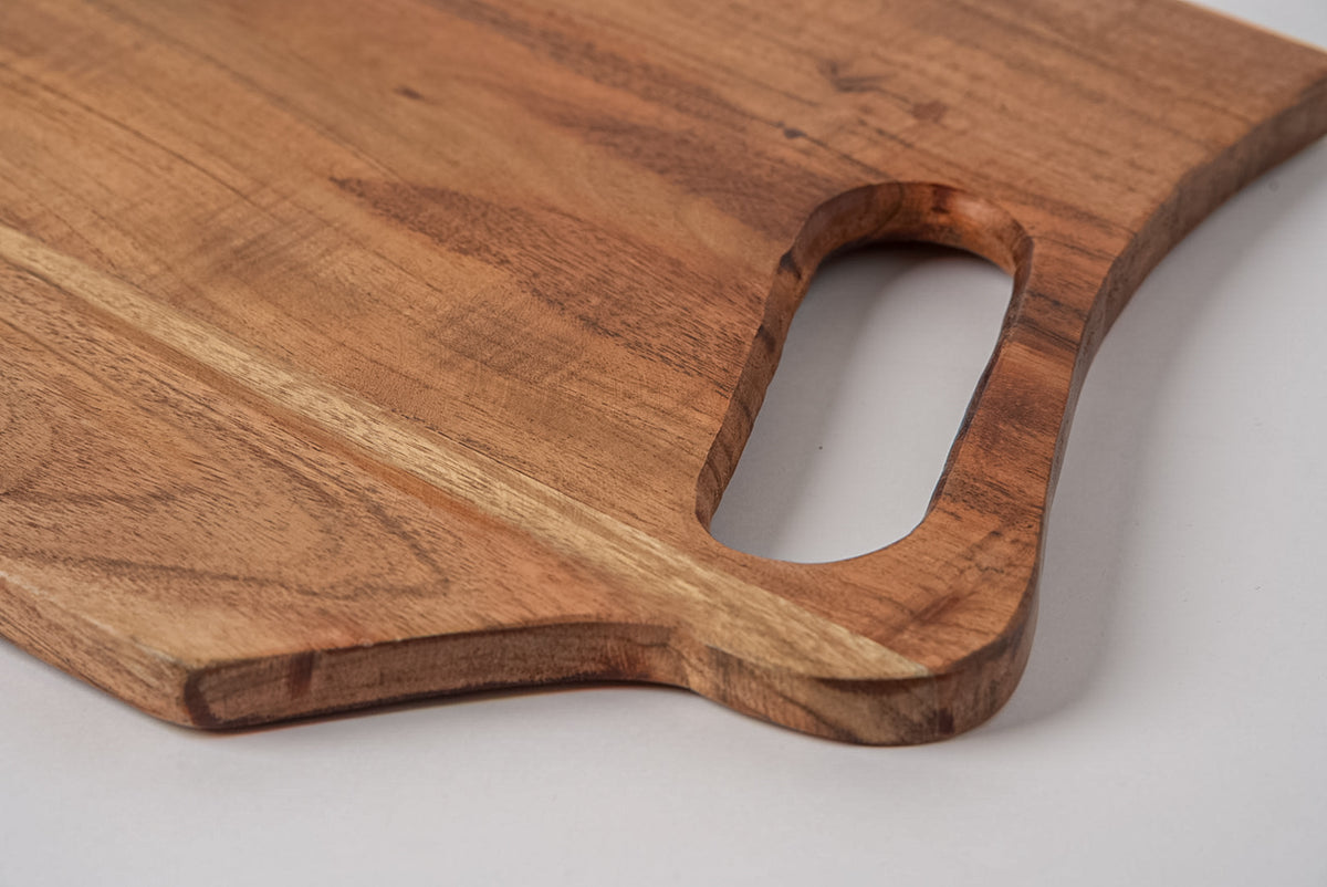 Rectangular acacia wood serving board with handle cutout and natural wood grain visible.