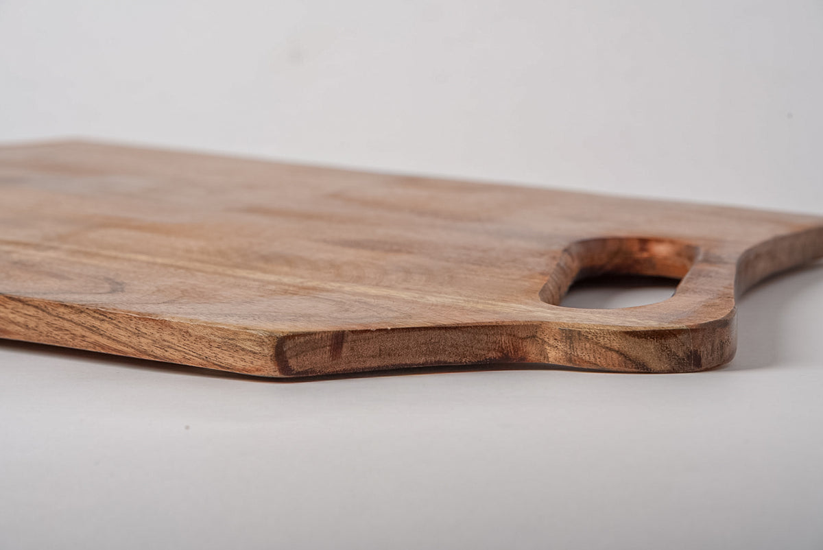 Rectangular acacia wood serving board with handle cutout and natural wood grain visible.