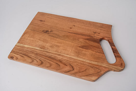 Rectangular acacia wood serving board with handle cutout and natural wood grain patterns.