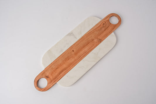White marble rectangular serving board with wood handles featuring circular cutouts on each end.