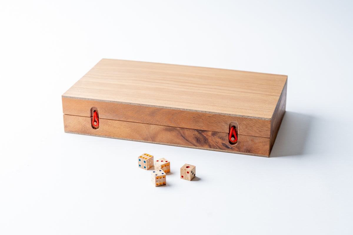 Wooden backgammon set with light natural finish, red metal latches, and wooden dice displayed in front.