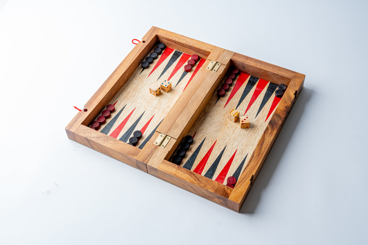 Wooden backgammon set with red and black pieces arranged on striped playing surface with dice and gold-toned checkers.