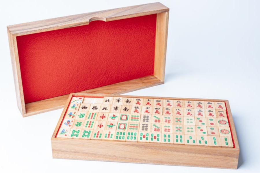 Mahjong set with wooden tiles in storage box and red fabric-lined wooden case.