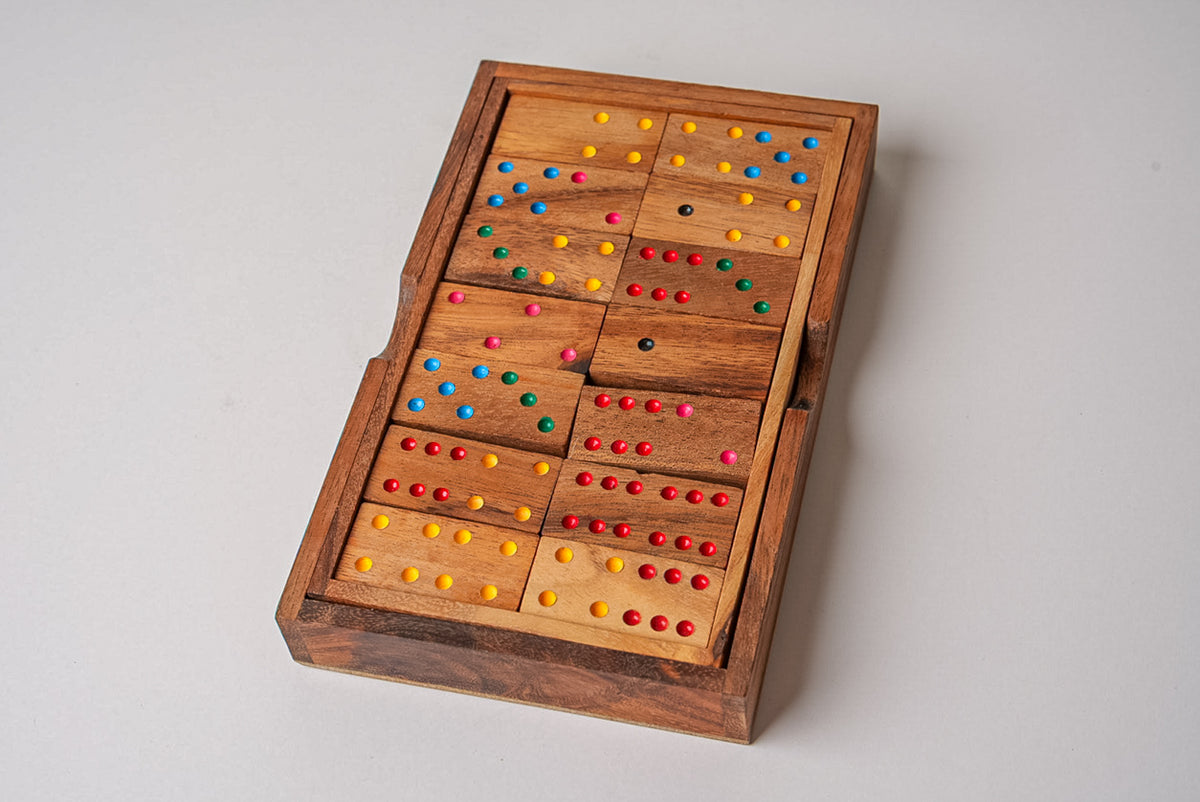 Wooden domino set with colorful painted dots arranged in a wooden box with compartments.