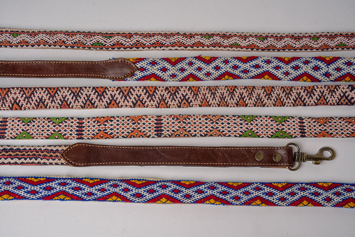 Collection of woven dog leashes and collars with geometric Kilim patterns in various colors including orange, blue, brown, an