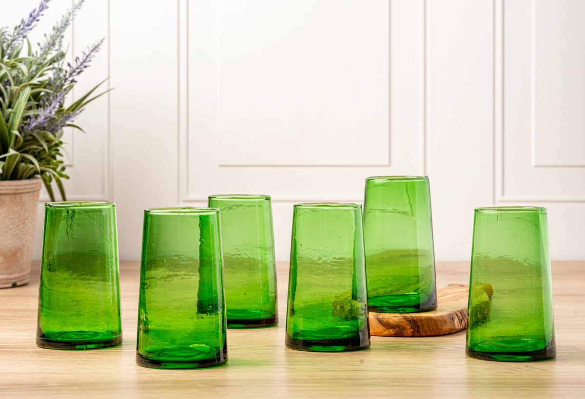 Six green cone-shaped glasses with textured surface displayed on wooden table.