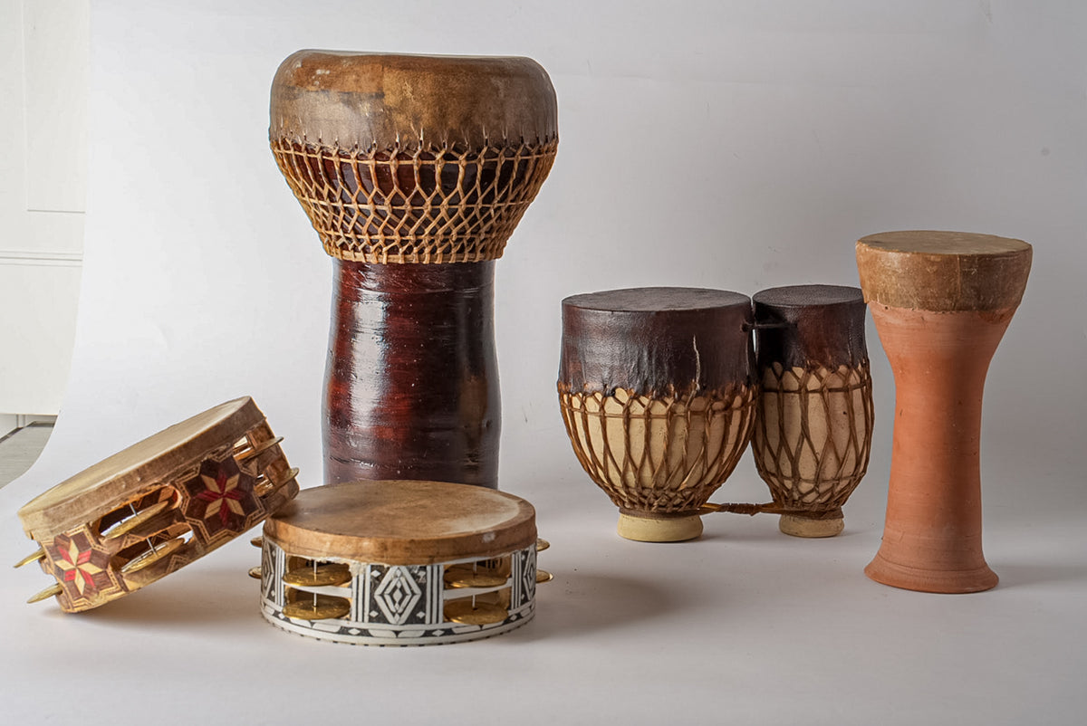 Collection of Moroccan hand drums including goblet-shaped, cylindrical, and frame drums with cord and leather detailing.