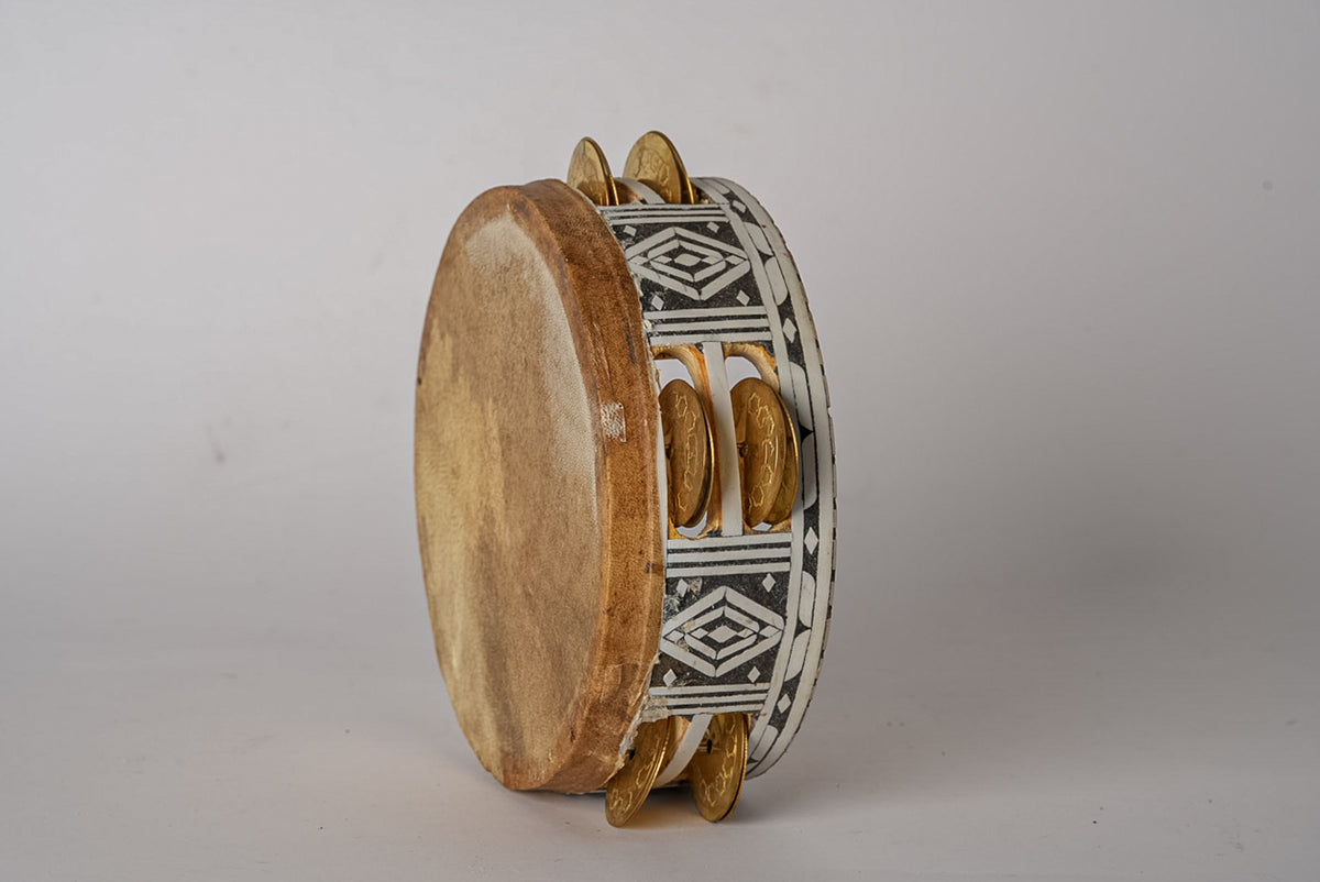 Wooden tambourine with natural wood frame, geometric patterned fabric band, and brass jingles arranged in rows.