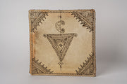 Square Moroccan drum with natural leather surface featuring geometric and ornamental line designs in brown ink.