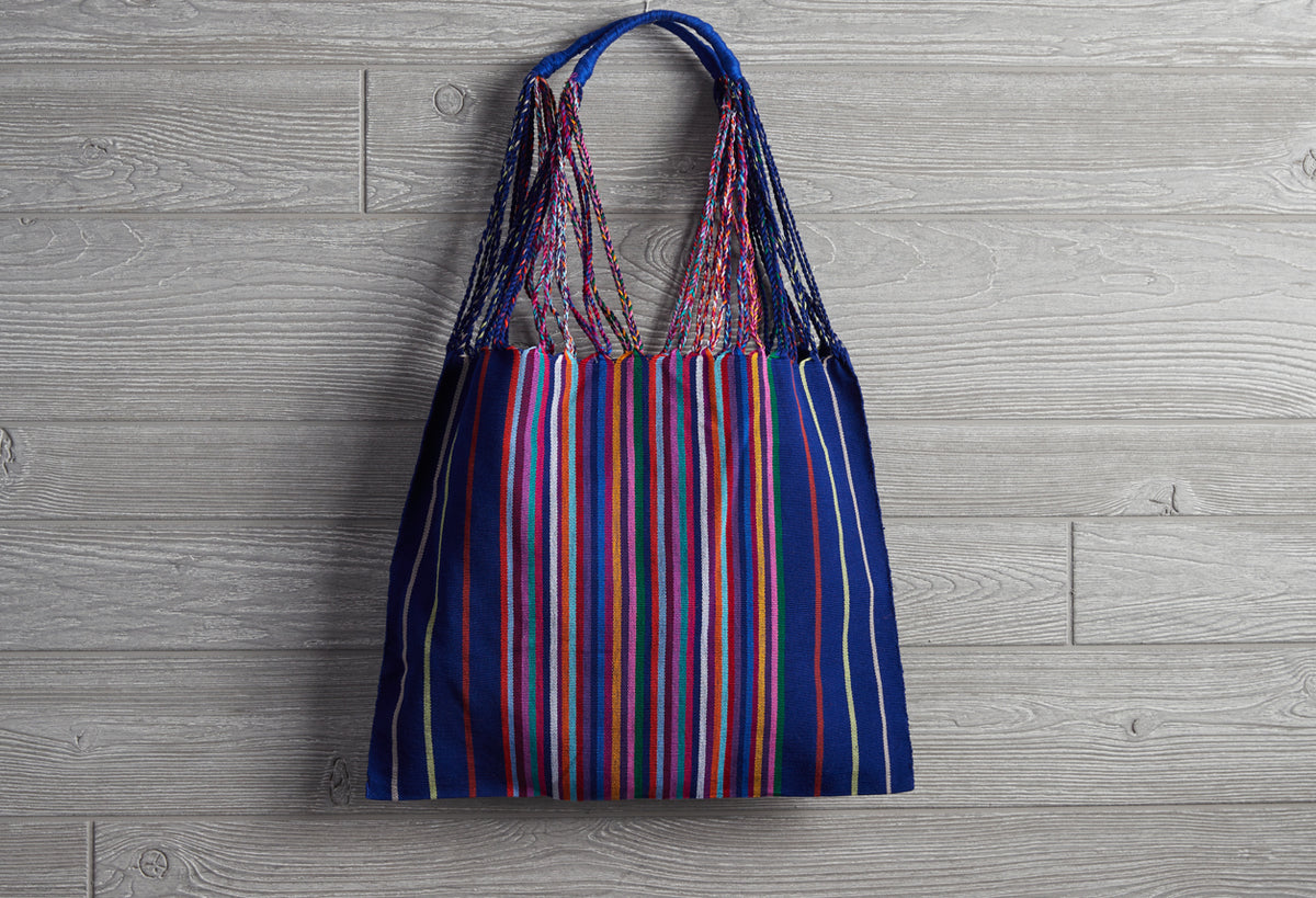 Woven market bag with blue, red, and white vertical stripes and blue braided handles.