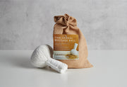 White Thai herbal massage ball in burlap pouch with turmeric and lemongrass label.
