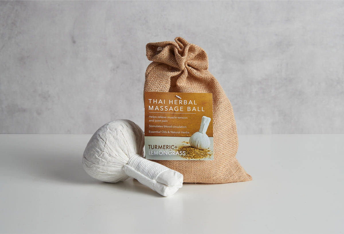 White Thai herbal massage ball in burlap pouch with turmeric and lemongrass label.